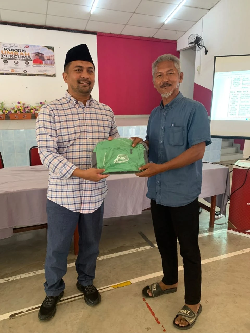 YB Dato’ Mohd Zaidy menyerahkan beg KRS kepada seorang jemaah lelaki warga emas