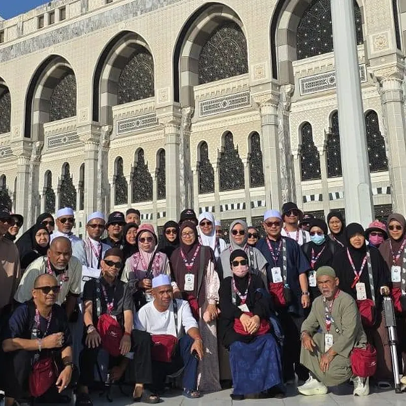 Rombongan jemaah haji KRS Travel bergambar beramai-ramai di perkarangan Masjidil Haram dengan latar Menara Jam Makkah