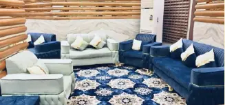 Ruang santai Dar al-Salah Hotel Aziziyah dengan sofa baldu biru, kerusi berlengan dan permaidani bercorak